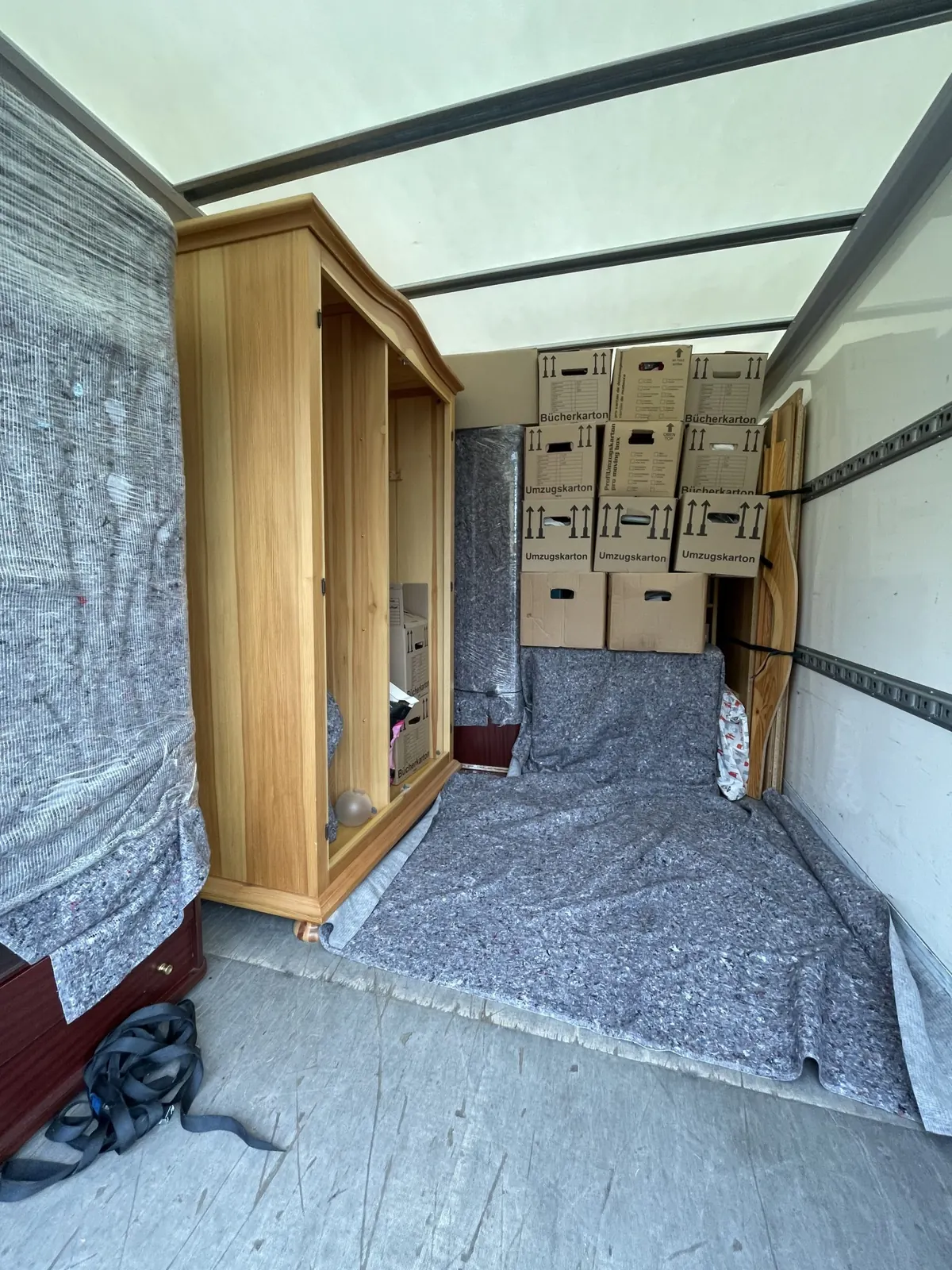 Koffer-LKW innen, Schrank und Kartons mit Decken gesichert