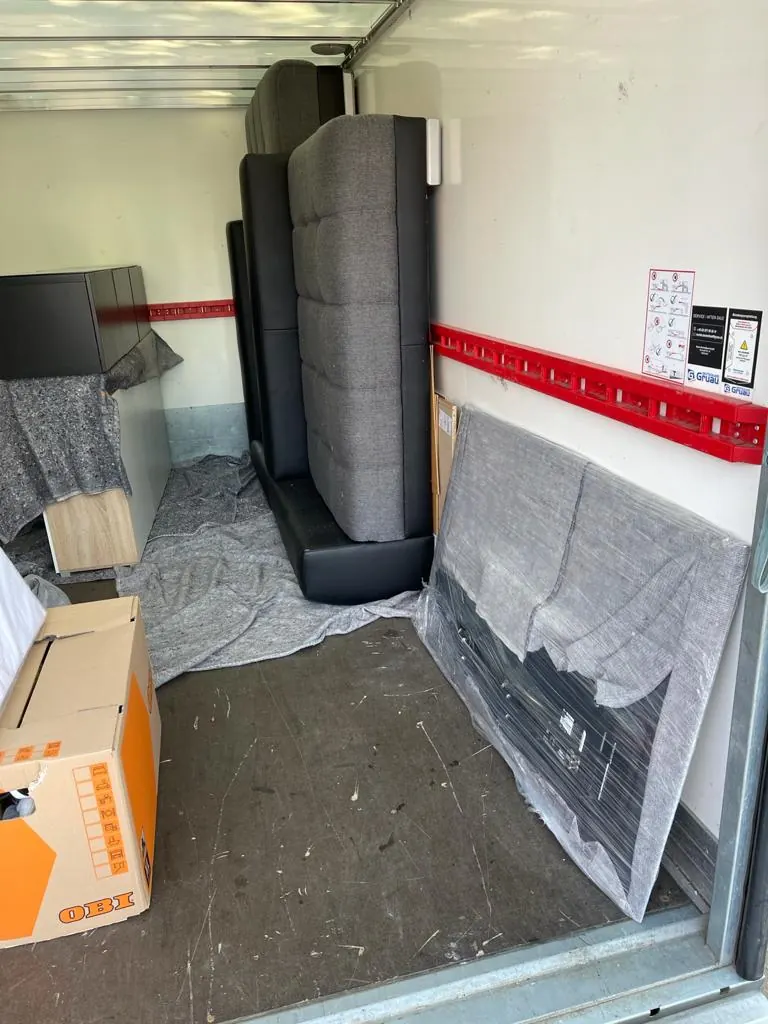Laderaum mit Sofa, Spiegel und Kartons, festgezurrt